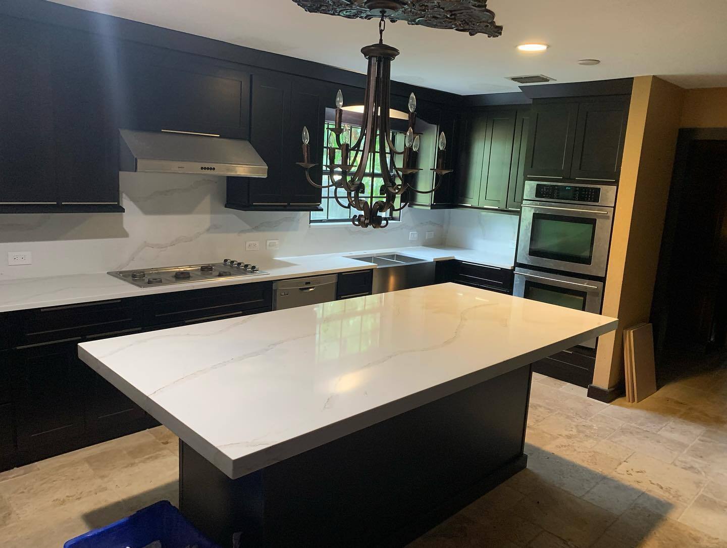 Completed kitchen remodel with dark cabinetry and quartz island by Horizon Elite Renovations
