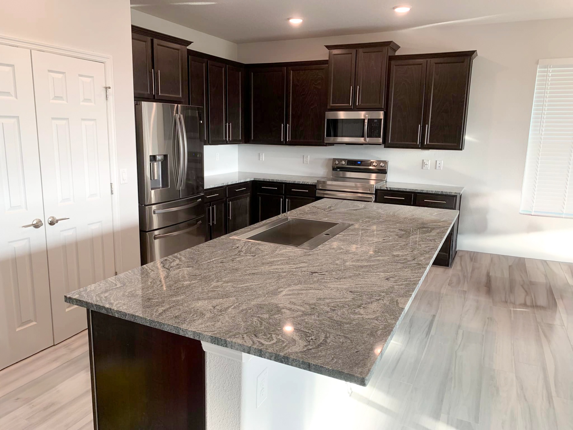 Completed kitchen remodel with granite island and shaker cabinets by Horizon Elite Renovations